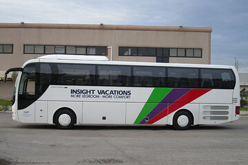 MAN R. Coach della flotta Angelino, vista laterale, bianco con fasce colorate, con la livrea di un tour operator