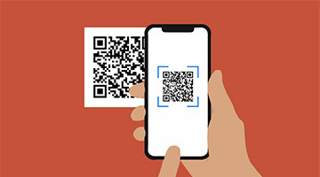 Una mano inquadra con lo smartphone un codice QR
